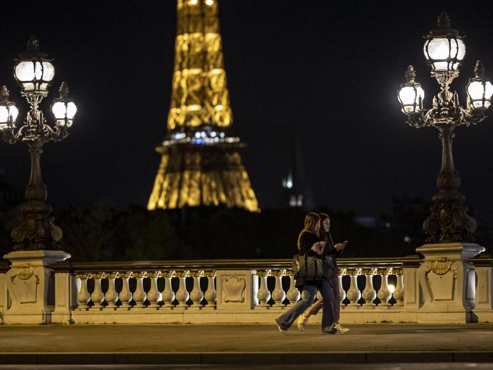 Dos jóvenes caminan por París momentos antes del inicio del toque de queda en la ciudad.