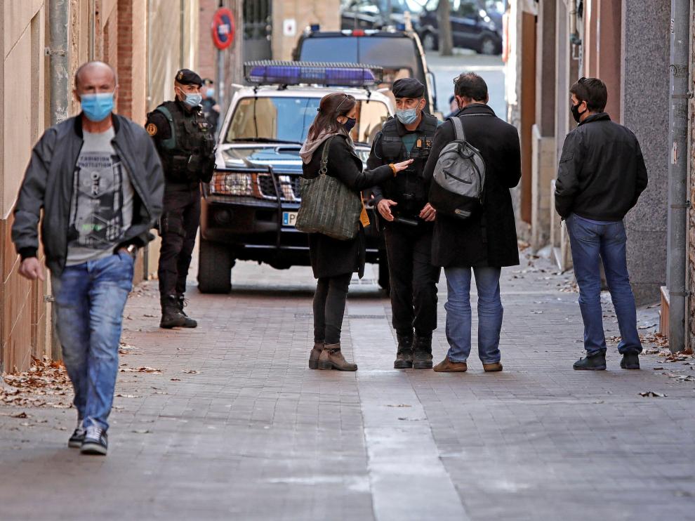 La exdiputada de ERC Marina Llansana (i), habla con agentes de la Guardia Civil tras la detención de su pareja, Oriol Soler.