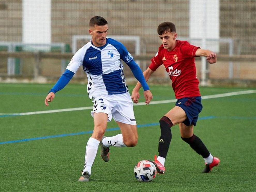 Un jugador del Osasuna controla el balón ante la presión del rival.
