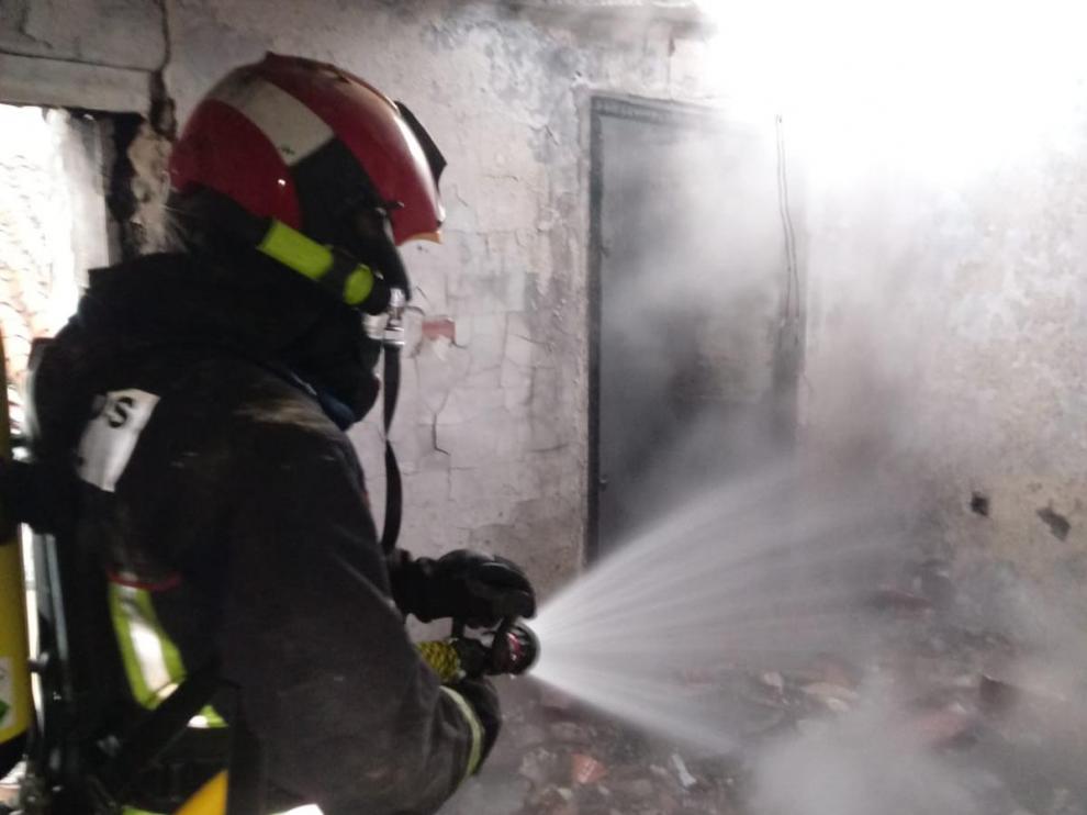 Un bombero trabaja para sofocar el incendio registrado en una vivienda de Utrillas.