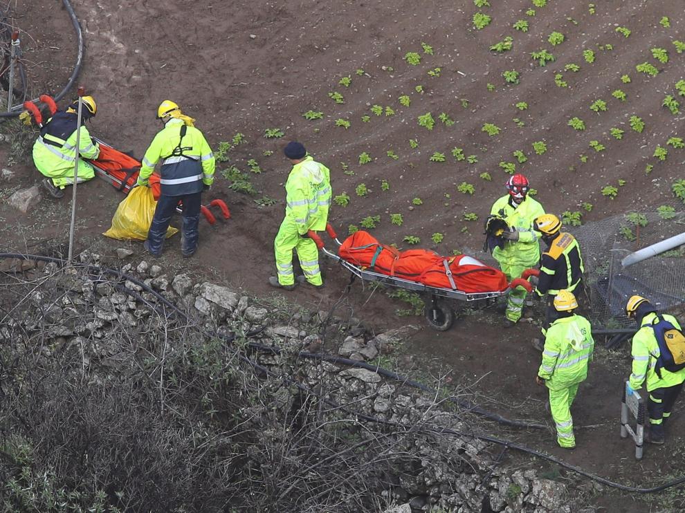 Los servicios de rescate recuperan dos de los cadáveres.