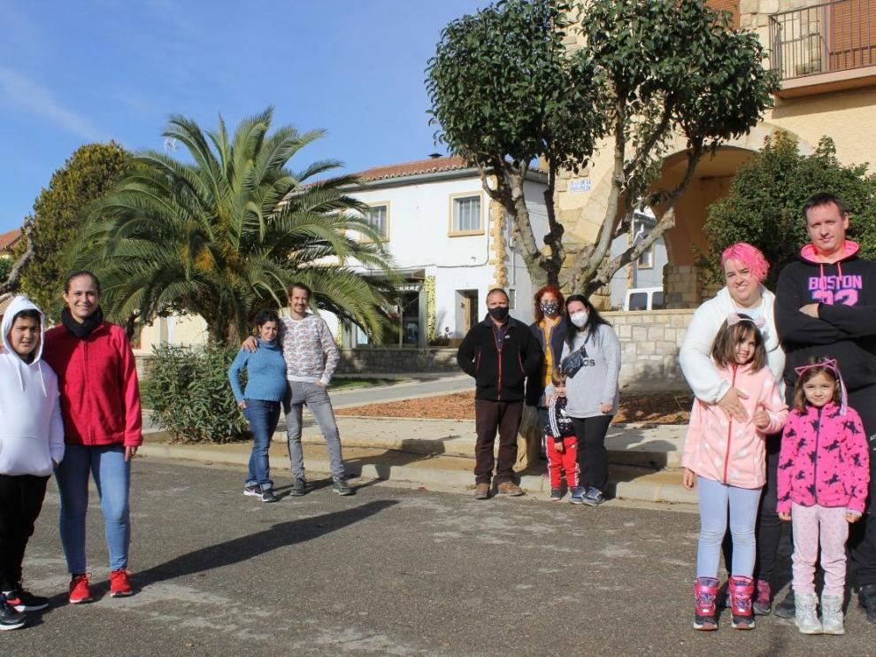 Ttres de las nuevas familias, junto a varios responsables municipales, en la plaza de la localidad de Sodeto.