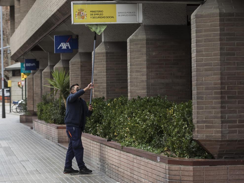 Un operario limpiaba esta miércoles por la tarde el cartel de la sede central del SEPE en Zaragoza, ubicada en Tenor Fleta.