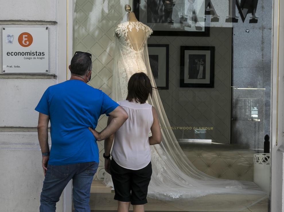 Una pareja mira un escaparate de una tienda de vestidos de novia en Zaragoza, en una imagen de archivo.