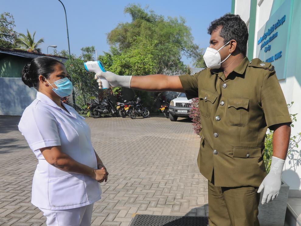 Un inspector toma la temperatura a una sanitaria, este sábado en Colombo (Sri Lanka).