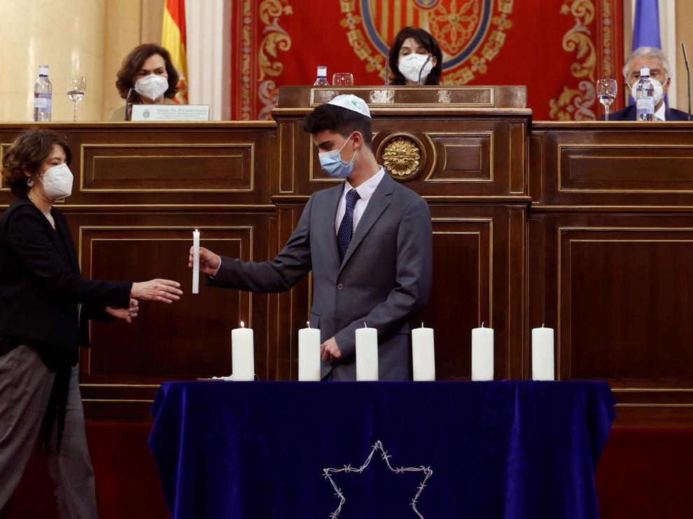 Un miembro de la comunidad judía entrega una vela en presencia de Carmen Calvo, Pilar Llop e Isaac Benzaquén, presidente de la Federación de Comunidades Judías de España,