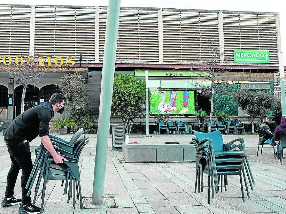 Un camarero recoge las sillas de una terraza en la zona de Romareda.