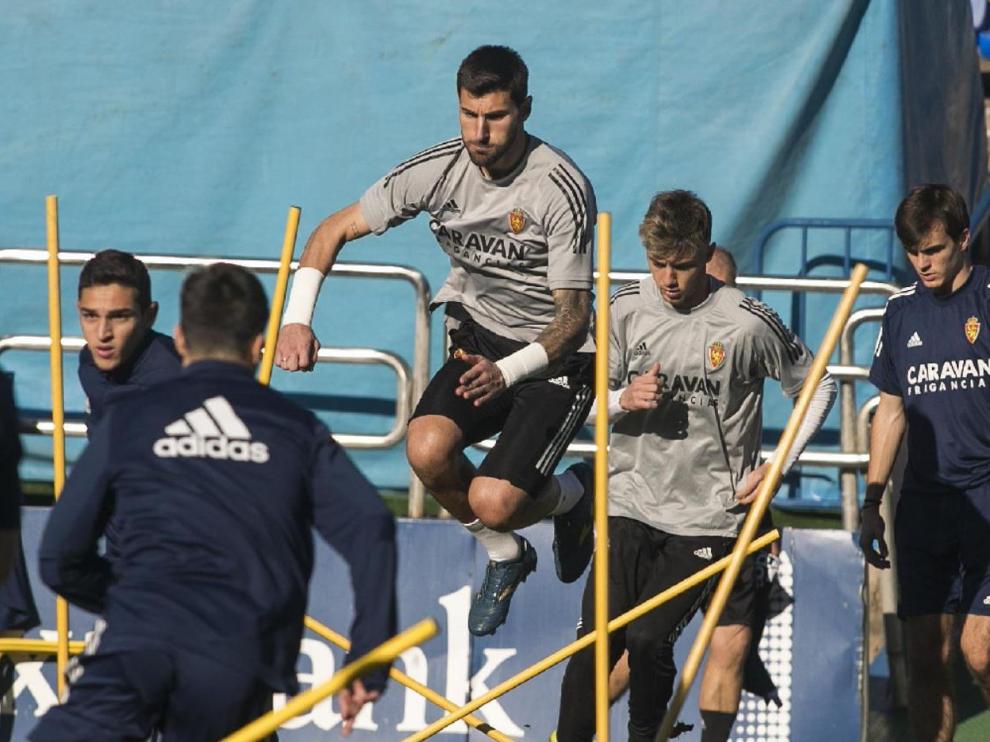 Álvaro Ratón, en pleno salto durante el último entrenamiento del Real Zaragoza, por delante del joven portero Carlos Azón, su pareja en la convocatoria de este domingo en Málaga.