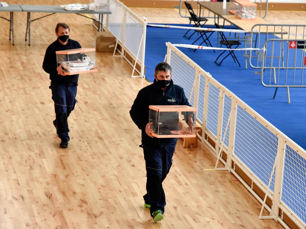 Dos trabajadores transportan urnas en el dispositivo electoral para los comicios catalanes, este sábado en Barcelona.