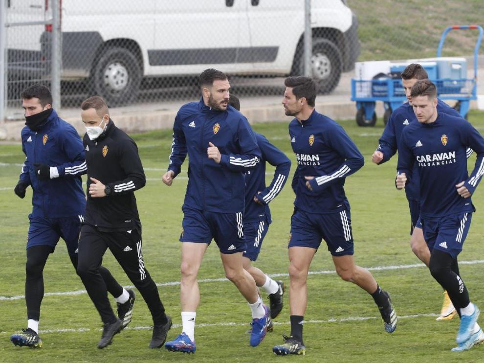 Zapater, primero a la izquierda con la cara cubierta del frío, ayer en el inicio del entrenamiento del Real Zaragoza.
