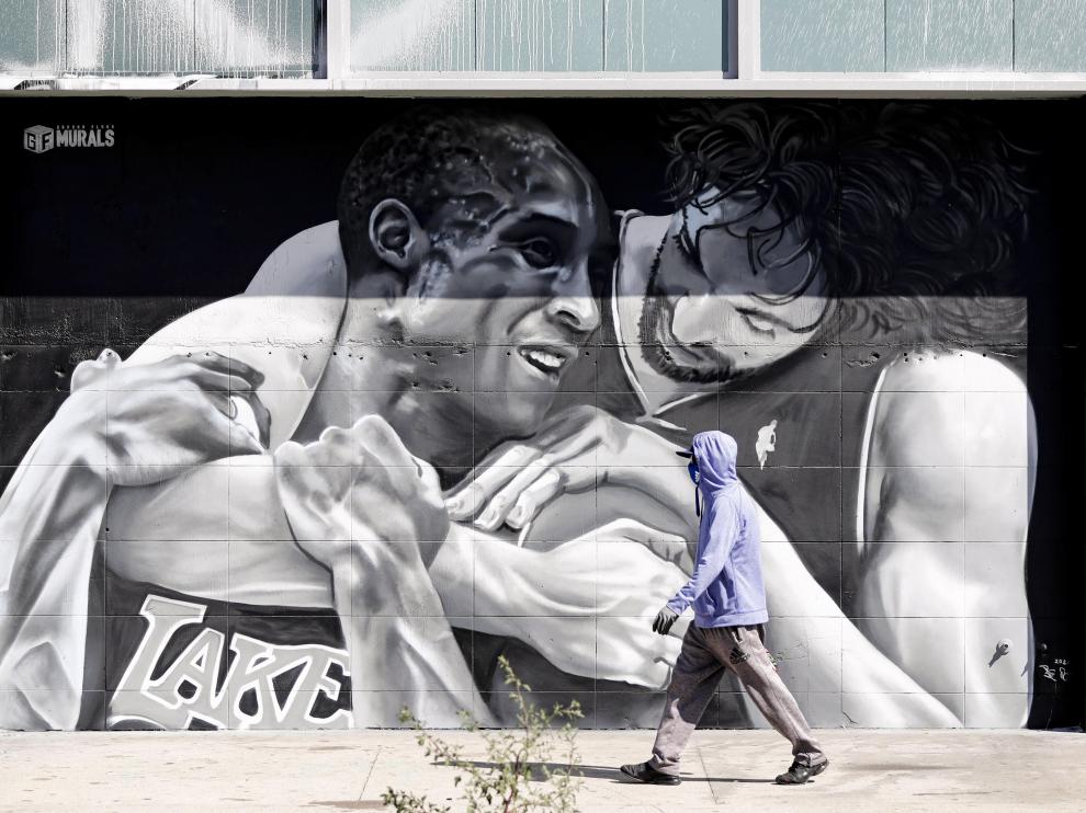 Un viandante pasa por delante del mural que refleja a los jugadores Pau Gasol y Kobe Bryant, en Los Angeles.
