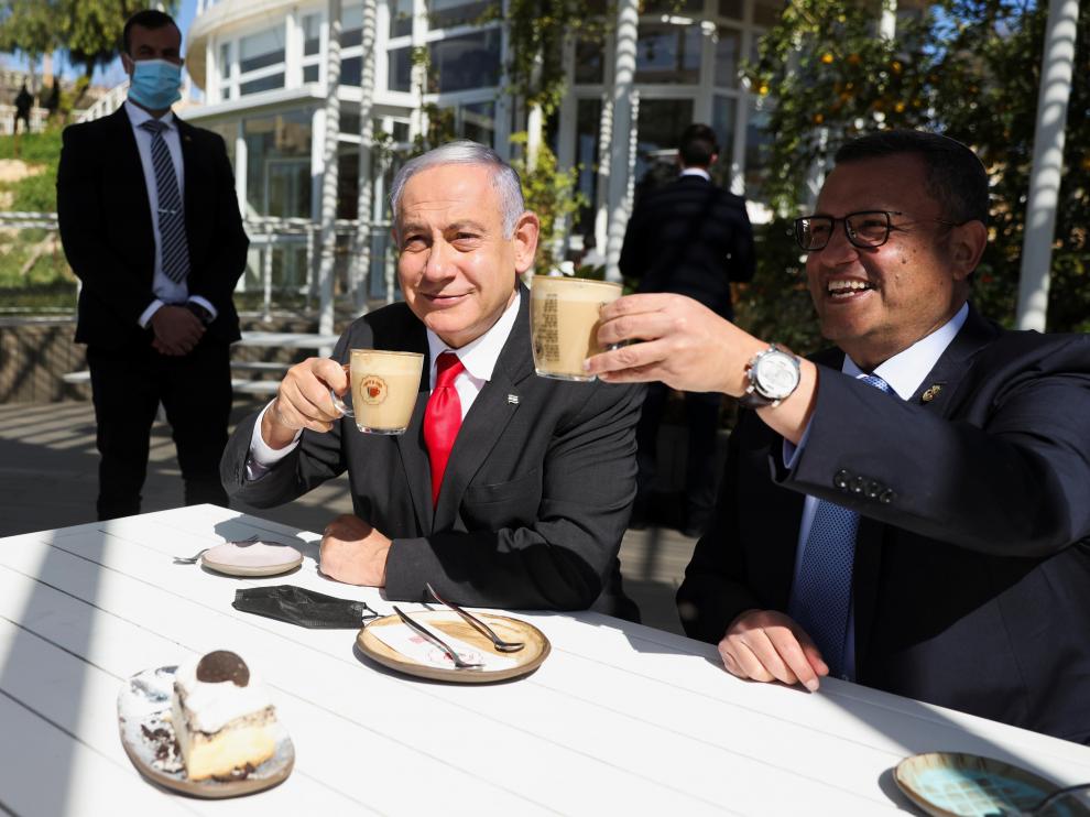 Israeli Prime Minister Benjamin Netanyahu drinks coffee with Mayor of Jerusalem, Moshe Leon, as they sit at a cafe while Israel further eases coronavirus disease (COVID-19) restrictions in Jerusalem