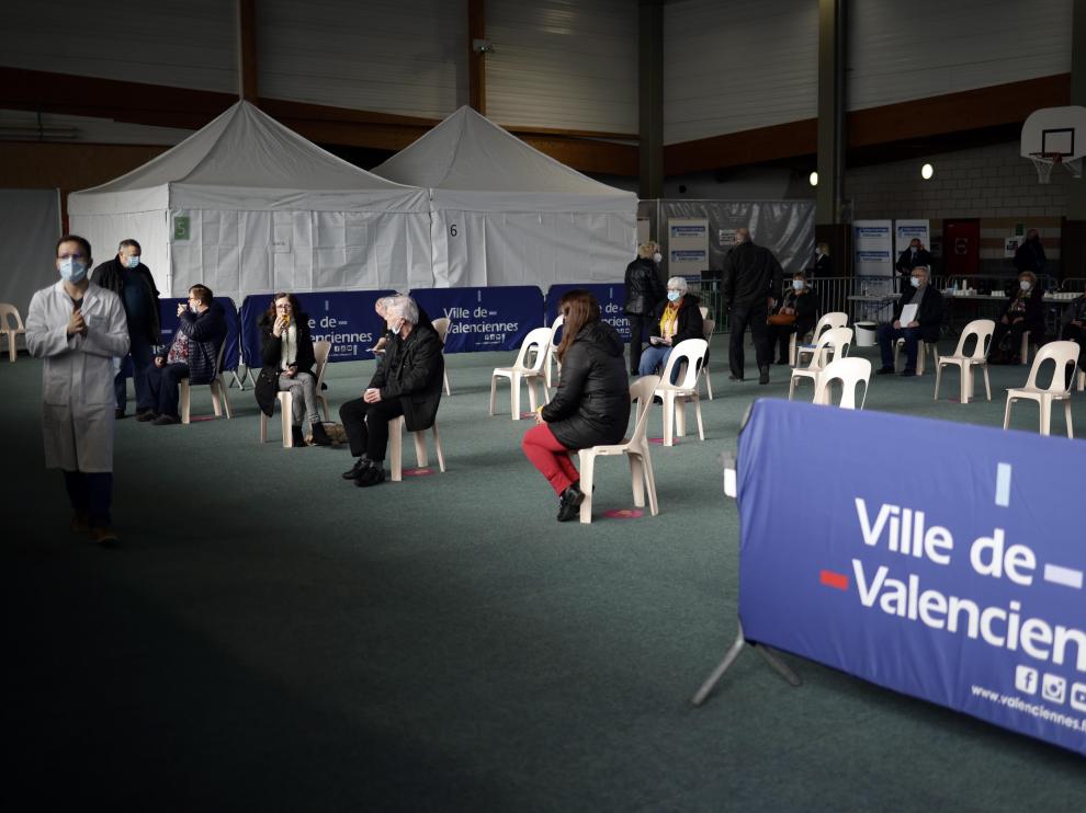 Varias personas esperan para vacunarse en un polideportivo en Valenciennes, Francia