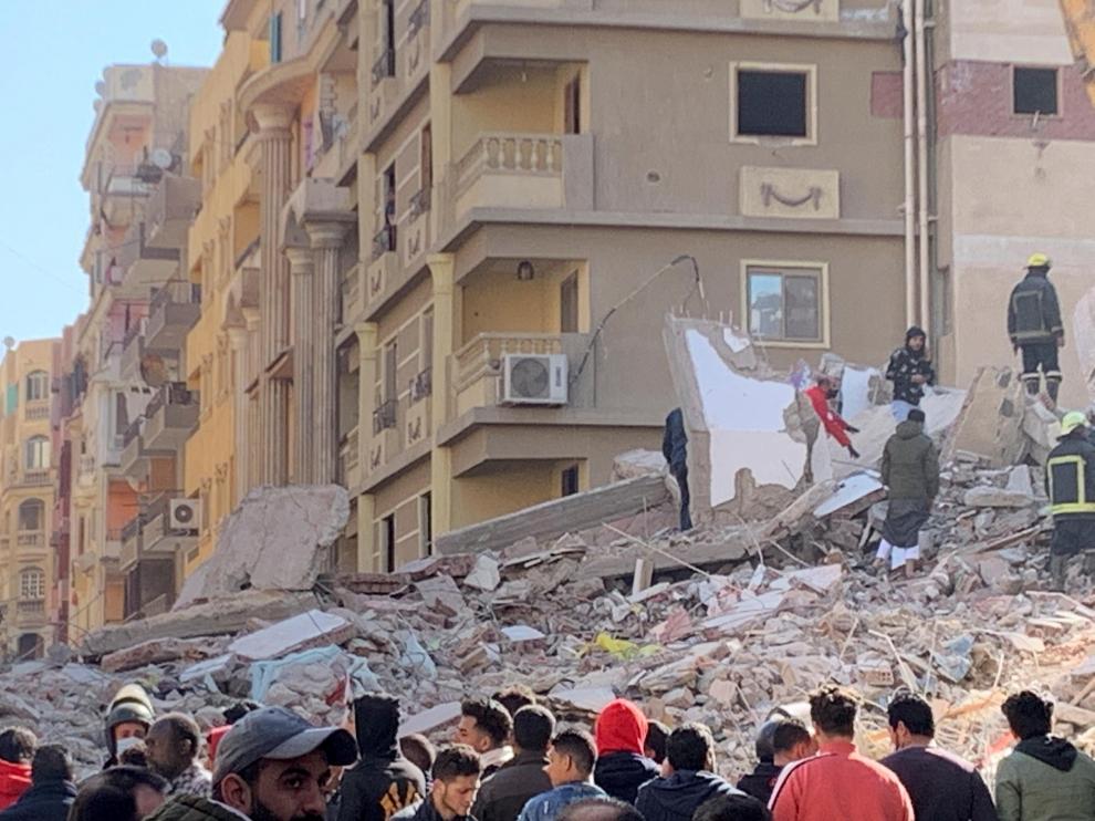 People inspect the area where a building was collapsed in Gesr al-Suez, Cairo