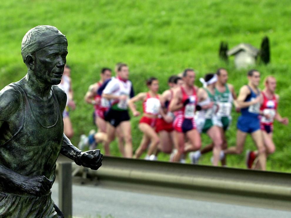 Imagen de archivo de un grupo de corredores pasando junto a la estatua del maratoniano Diego García, fallecido en Azpeitia mientras entrenaba