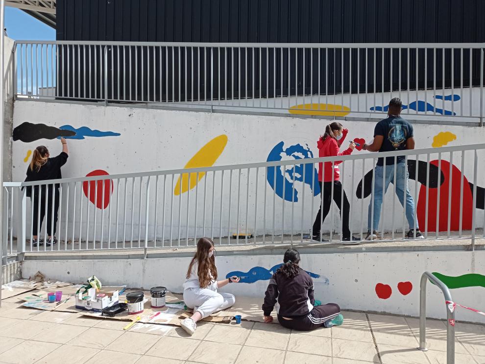 Los alumnos, manos a la obra para crear una obra de arte ambiciosa, una pintura mural en el patio del instituto, diseñada por Samuel Akinfenwa Onwusa