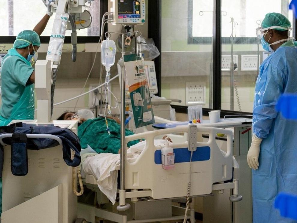 Dos médicos atienden a una paciente de covid en la India