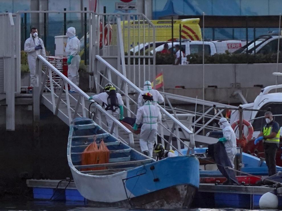 Trabajadores de la Cruz Roja trasladan los cuerpos de inmigrantes fallecidos en un cayuco durante la ruta migratoria hacia Canarias