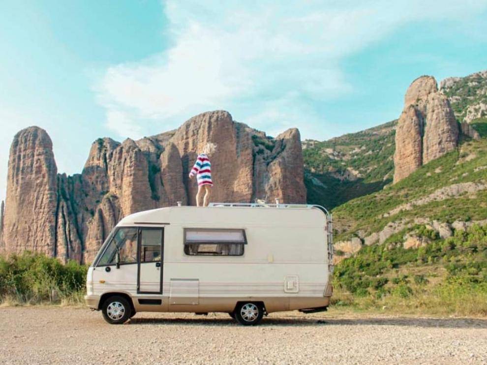 Patricia Parra, sobre el techo de su caravana, con los mallos de Riglos de fondo.