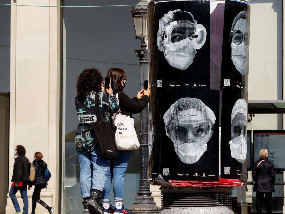 Jóvenes fotografían una iniciativa a favor de los sanitarios.