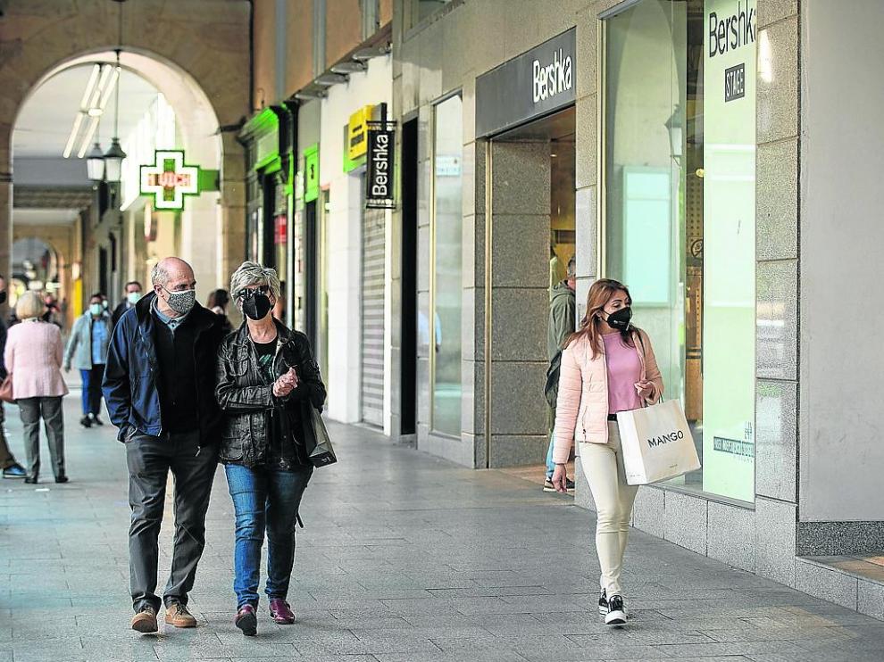 Varias personas pasean con bolsas frente a una tienda de ropa en Independencia, ayer.