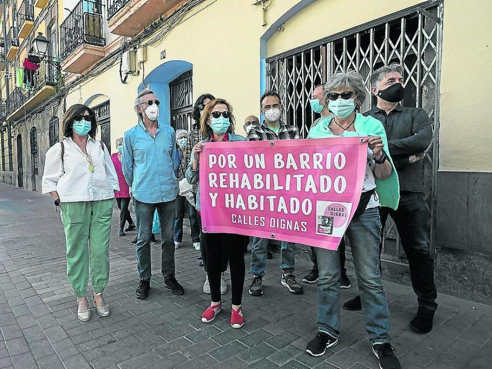 Varios vecinos muestran una de las pancartas de la campaña impulsada por Calles Dignas.