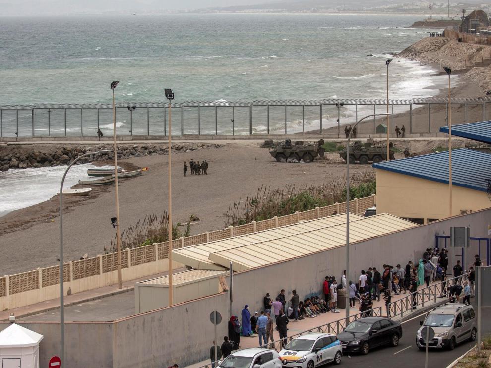 Varios migrantes esperan para pasar la frontera entre Ceuta y Marruecos voluntariamente