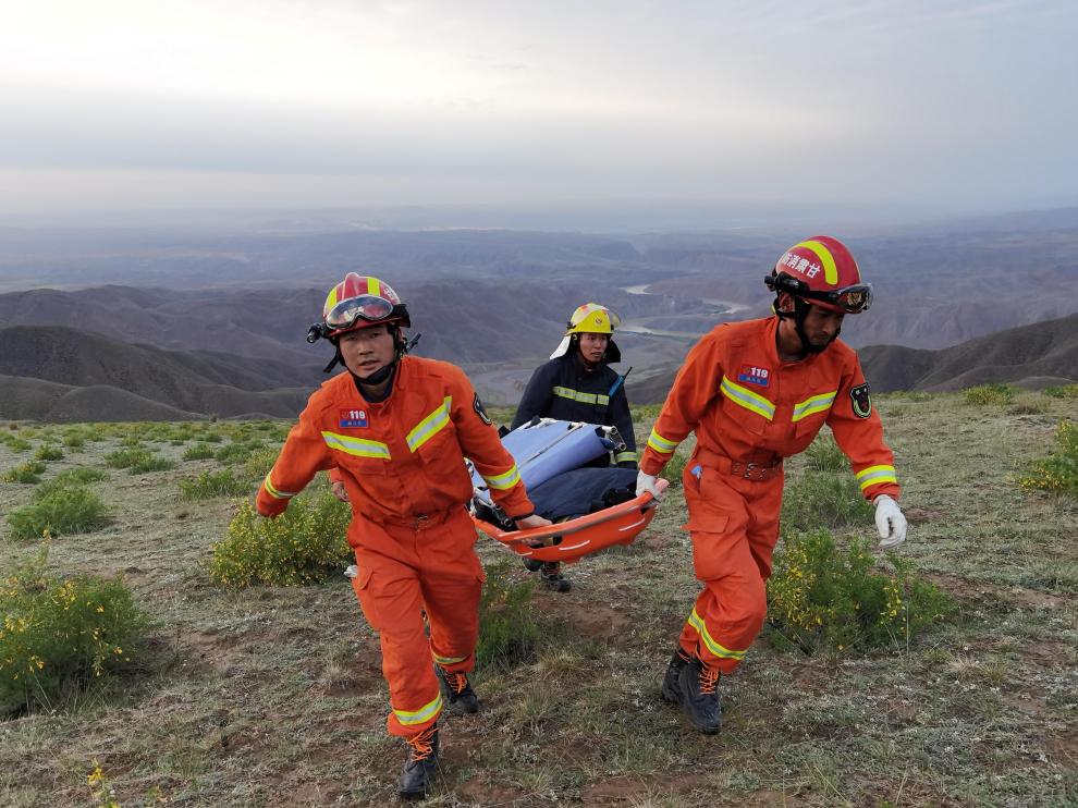 Varios rescatadores evacúan a una persona que participaba en la carrera.