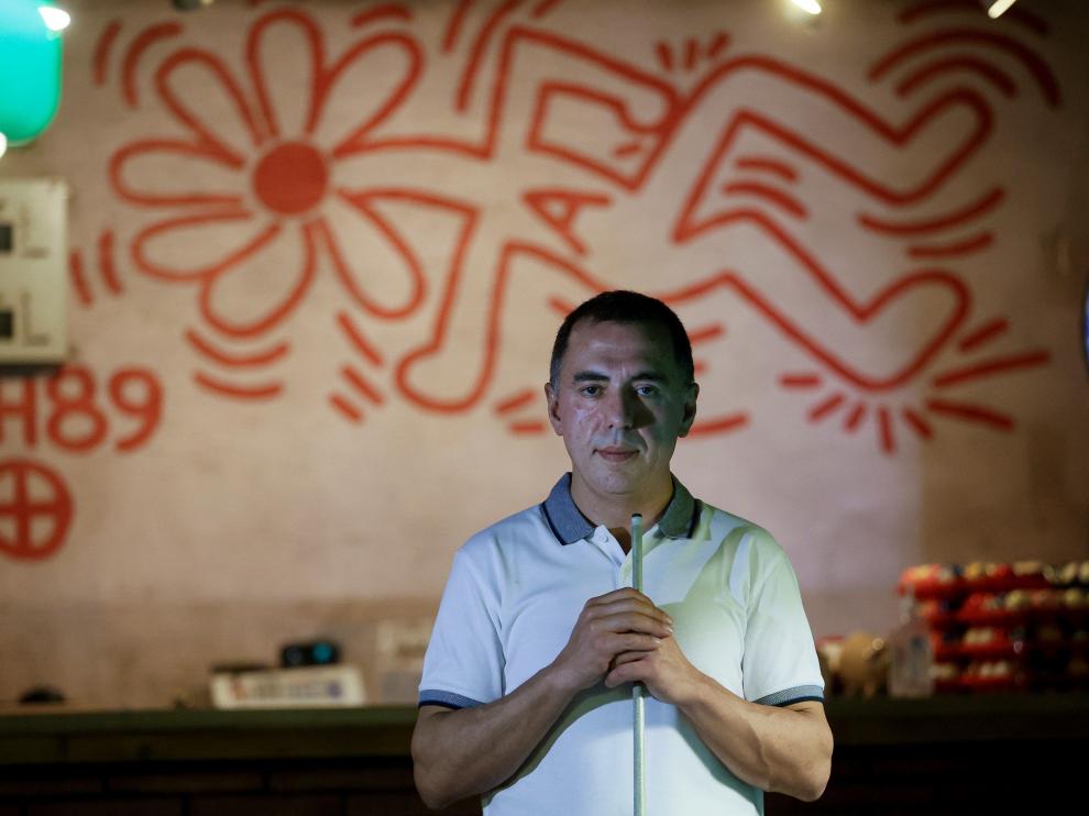 El propietario de Billares Ars, Gabriel Carral, posa en su local junto al mural que el artista neoyorkino Keith Haring