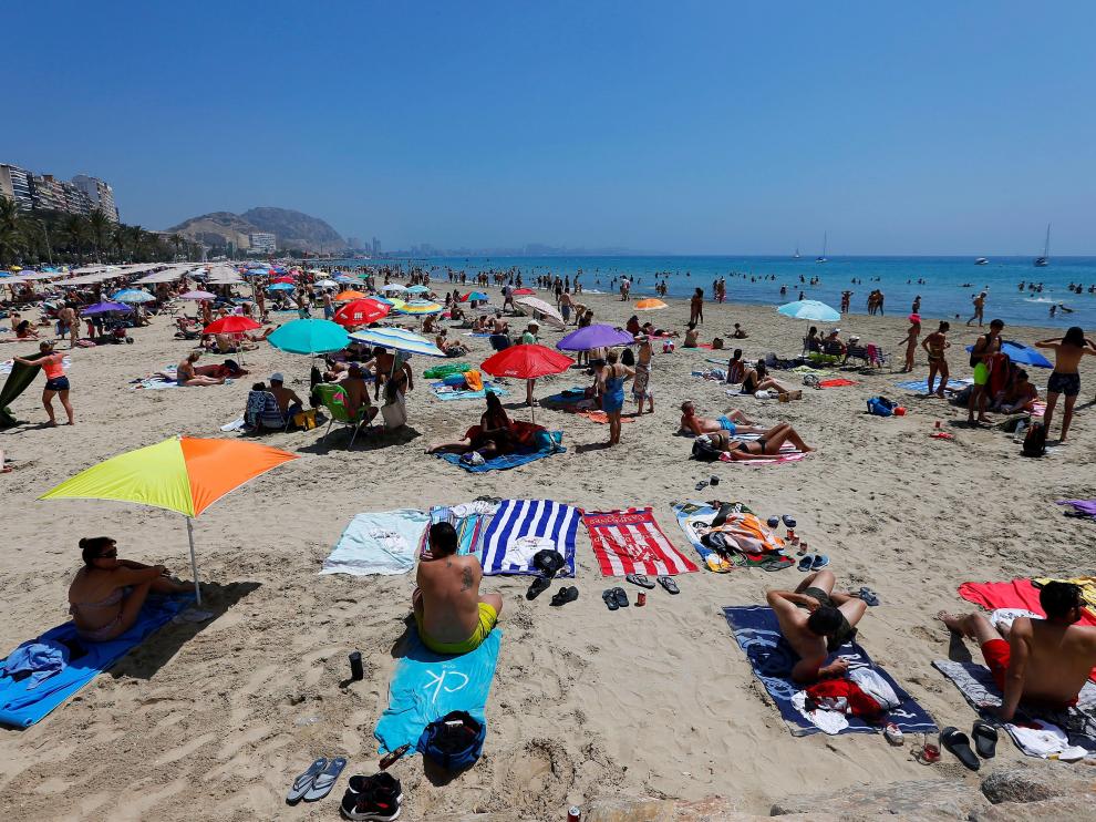 Turistas disfrutan de un soleado día en la playa del Postiguet, este sábado en Alicante.