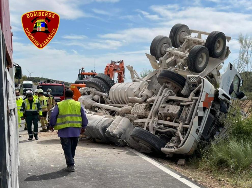 Los Bomberos de la DPZ trabajan para excarcelar el cuerpo del caminero fallecido y retirar el vehículo de la carretera, entre Azuara y Herrera de los Navarros.