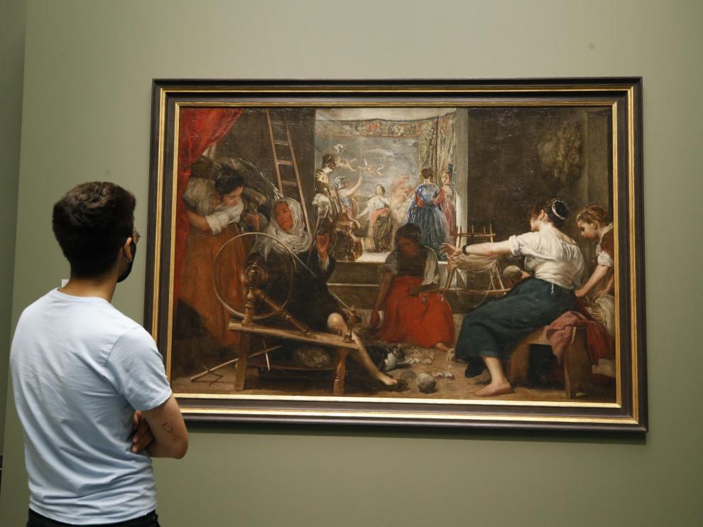 Un visitante observa "Las hilanderas" de Velázquez, que puede contemplarse desde este lunes en el Museo del Prado tal y como Velázquez quiso que se viera