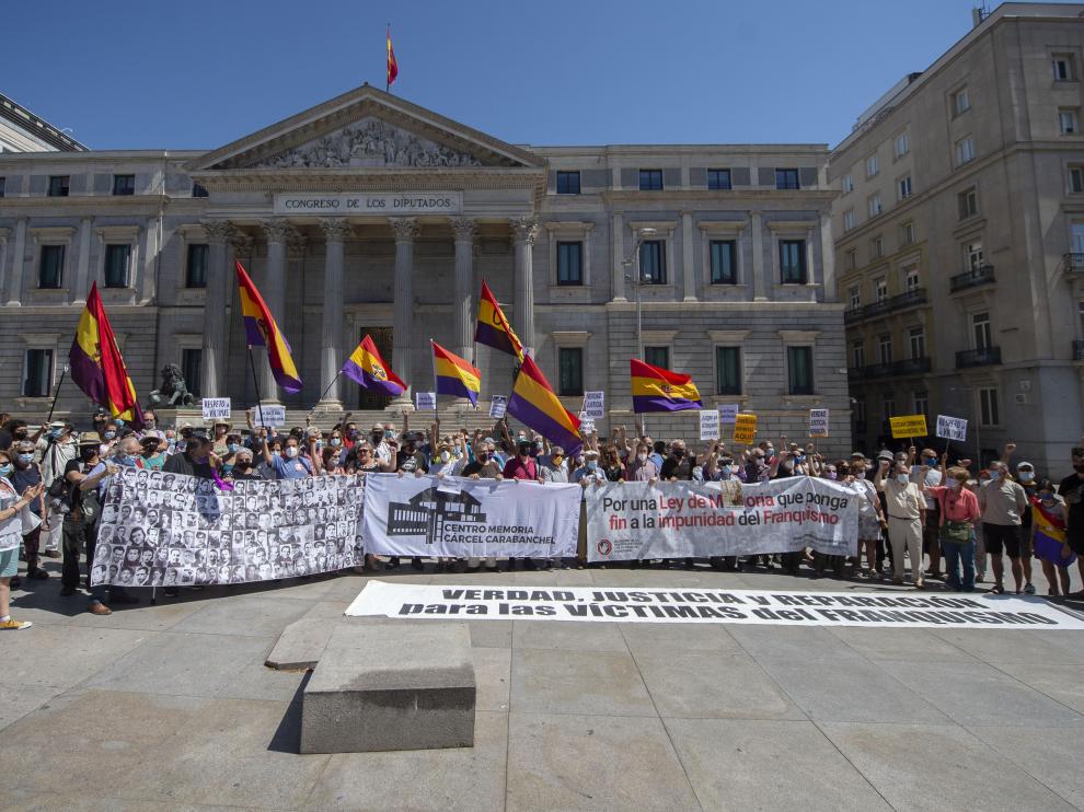 Varias decenas de personas participan en una concentración contra la impunidad del franquismo frente al Congreso de los Diputados, este domingo en Madrid.