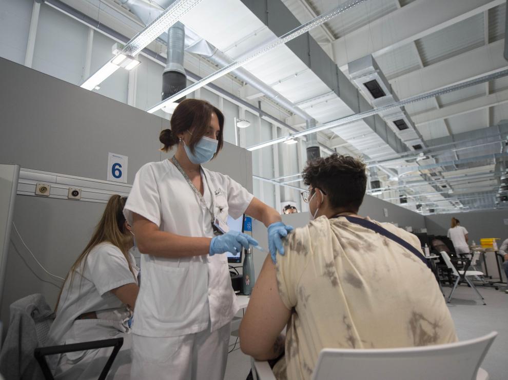 Un joven recibe la primera dosis de la vacuna de Pfizer en el Hospital Zendal.