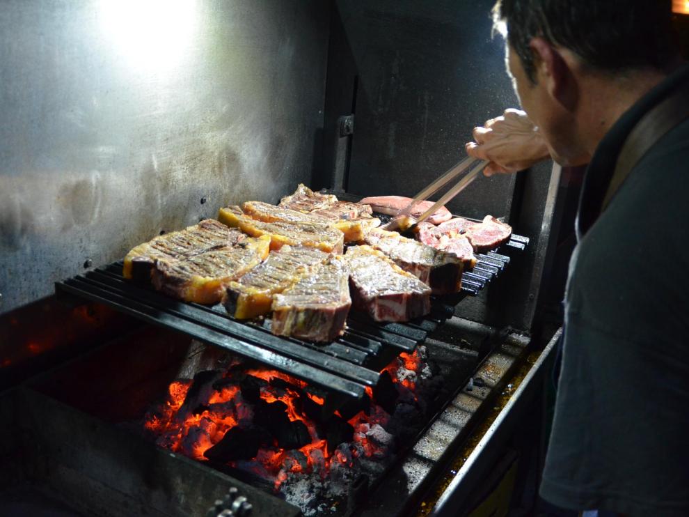 José Mármol, preparando varios chuletones en la barbacoa.
