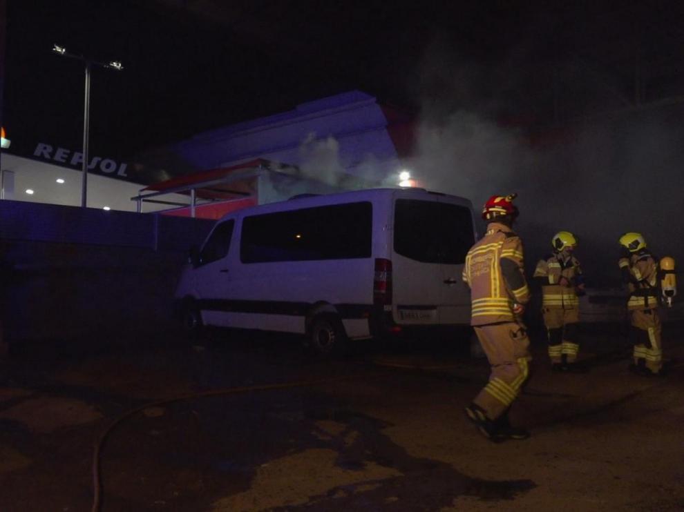 Los bomberos junto a los coches afectados por el fuego en Fraga.