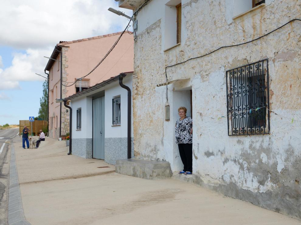Una vecina se asoma a la puerta de su casa en Allueva, donde deben recorrer 40 kilómetros para llegar a un supermercado.