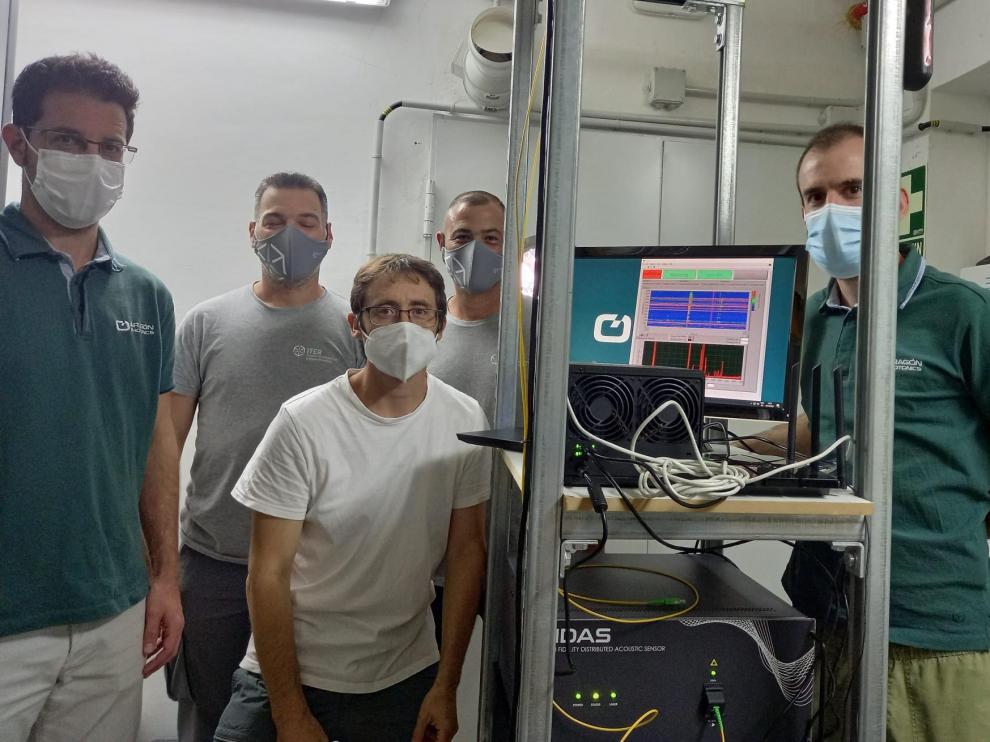 Los ingenieros de Aragón Photonics tras instalar su equipo en La Palma. En la máquina de abajo se lee HDAS, la caja patentada, que se conecta a una pantalla para ver los datos que está recogiendo. La línea vertical que se aprecia en el monitor es un terremoto.