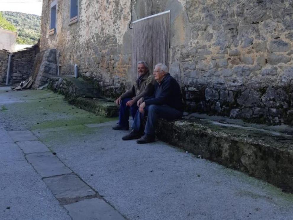 Alejandro y Pablo, sentados delante de su casa