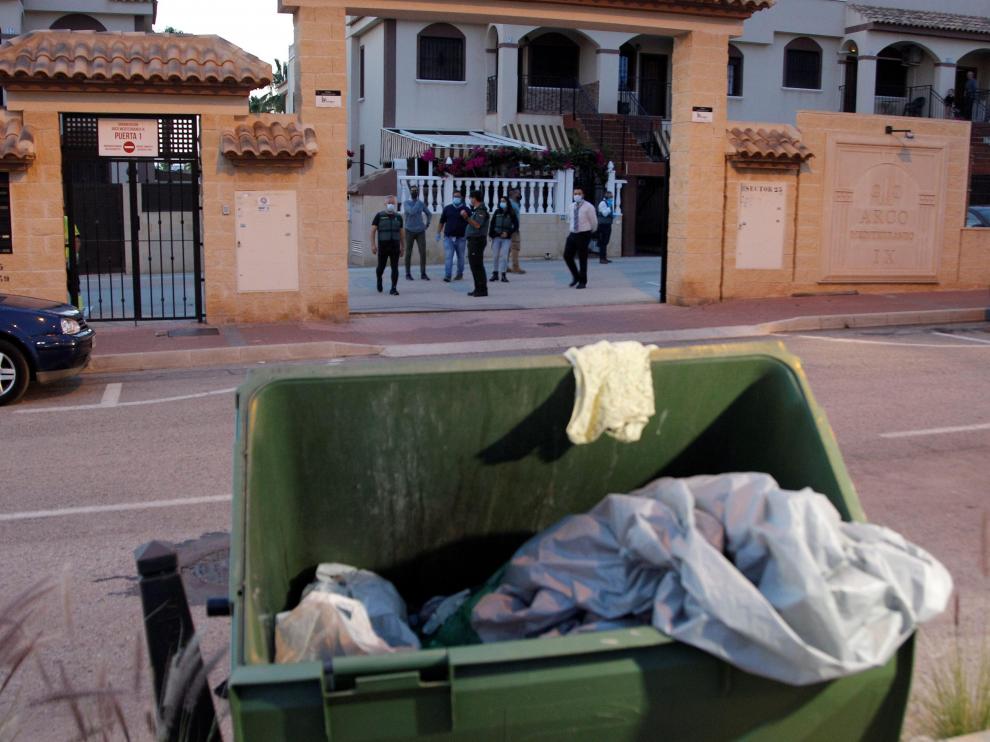 Agentes de la policía científica registran en una urbanización cercana a la zona donde se han encontrado los restos humanos en un contenedor.