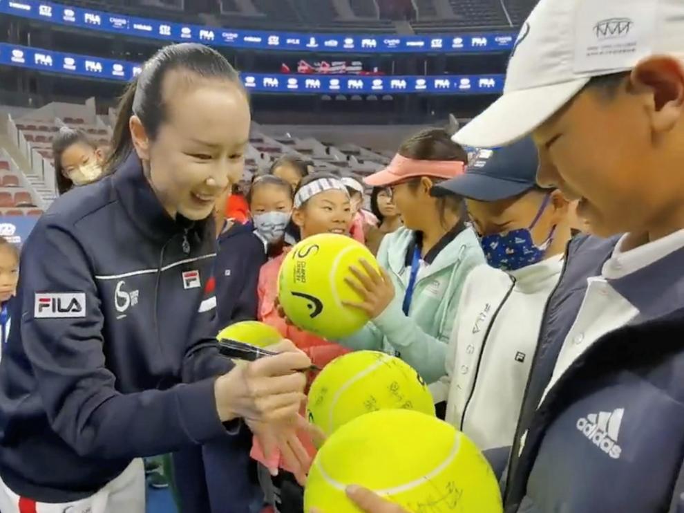 La tenista Peng Shuai firma autógrafos en un torneo infantil en China, tras su desaparición de la escena internacional.