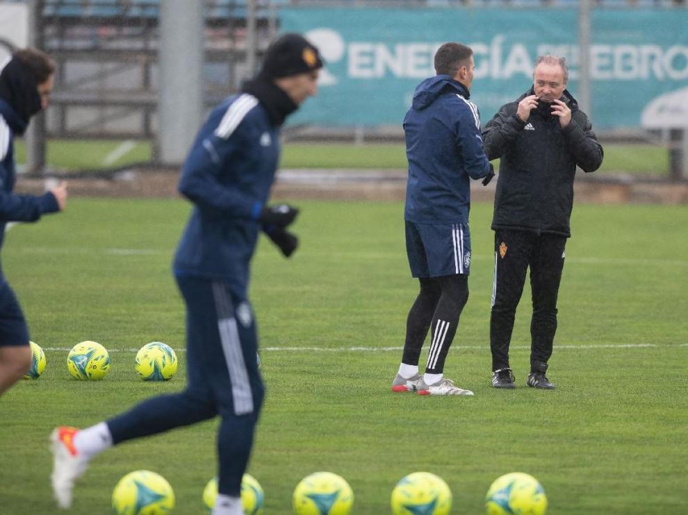 Juan Ignacio Martínez ‘Jim’ charla con el capitán, Alberto Zapater, mientras el resto del equipo corre al inicio del entrenamiento.