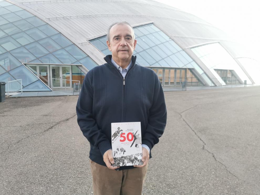 Pepe Arbués, con su libro, delante de la pista de hielo.