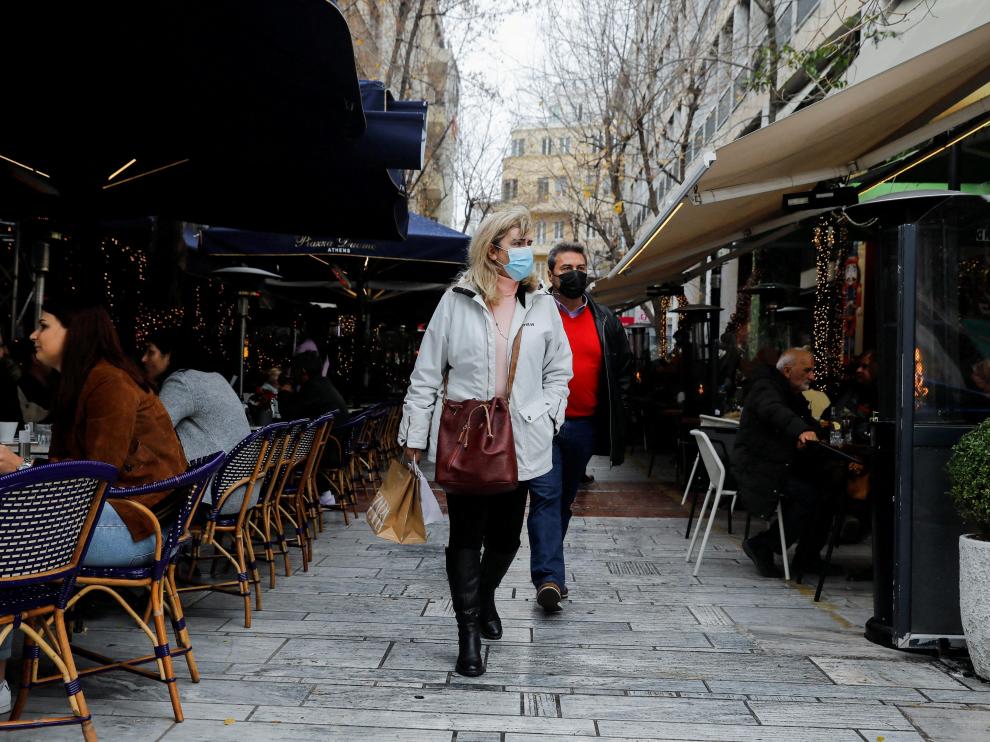 Dos personas caminan con mascarilla por una calle de Atenas, en una imagen de archivo.