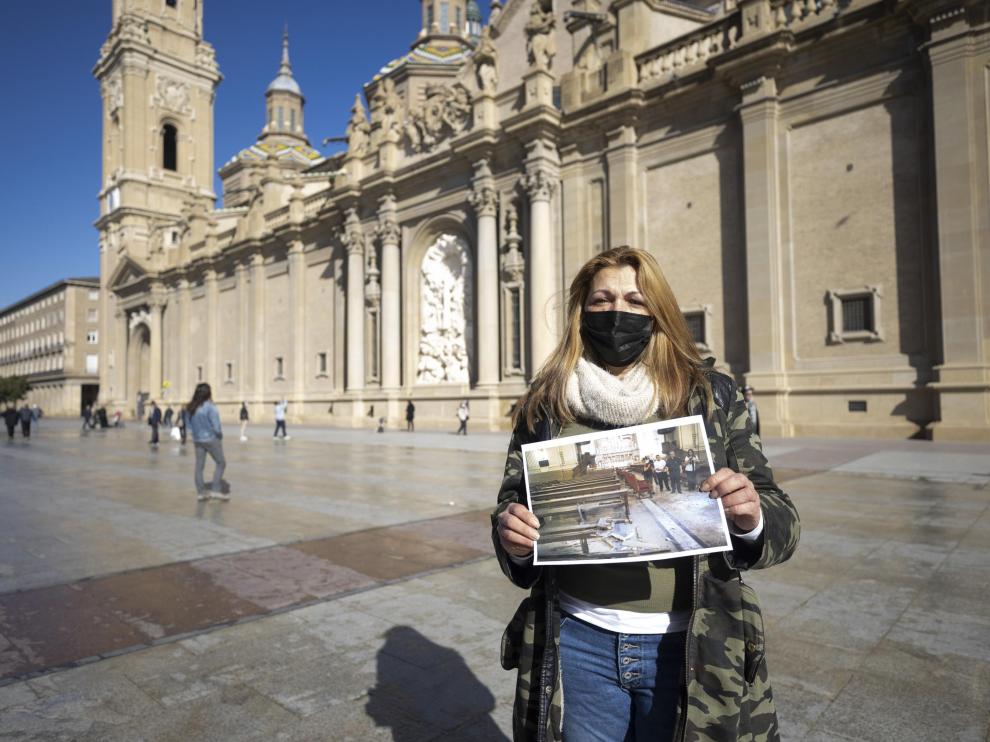 La víctima María García Simón, de 45 años, en la plaza del Pilar sostiene una fotografía del atentado en la Basílica en 2003.