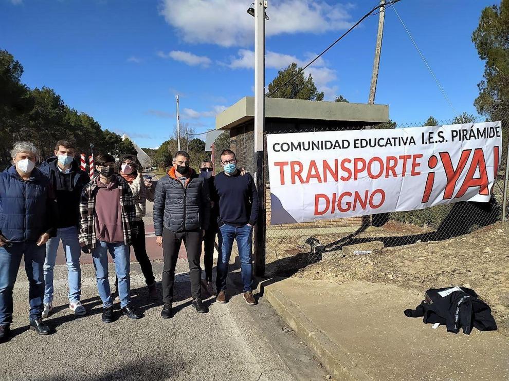 Representantes del Consejo Escolar junto ala pancarta colocada en el vallado de acceso al IES Pirámide
