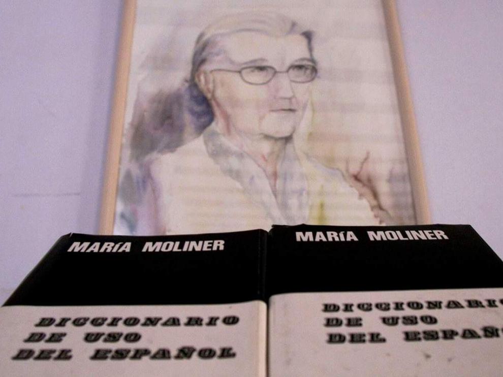 Un ejemplar del Diccionario de Uso del Español, junto a un retrato de María Moliner, en la biblioteca de Paniza.