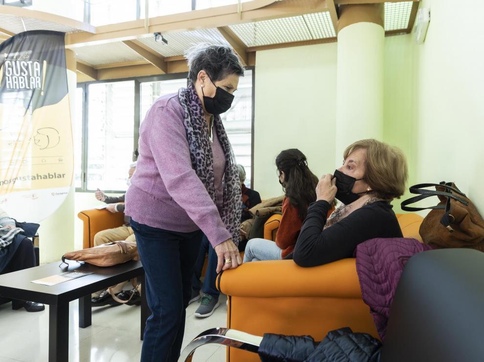 Rosa (de pie) conversa con otra de las usuarias del programa 'Nos Gusta Hablar', en el centro municipal de convivencia para personas mayores Laín Entralgo de Zaragoza.