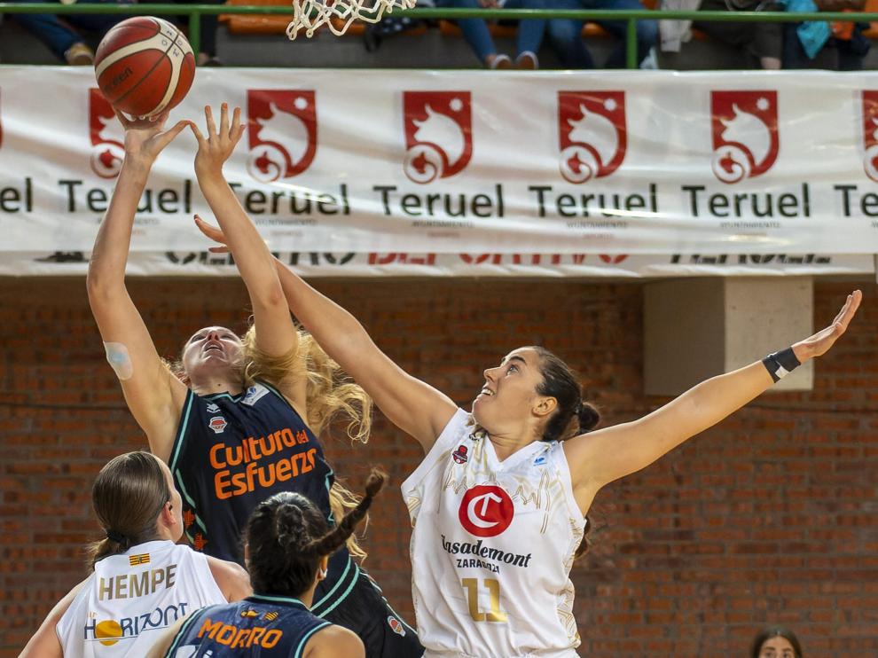 Vega Gimeno trata de taponar el lanzamiento de una jugadora de Valencia Basket, durante el amistoso disputado en Teruel.