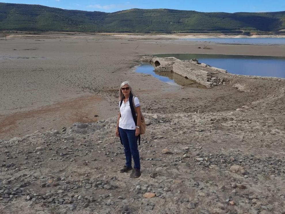 Ana Arbués, nacida en Tiermas, ante el puente de la carretera que oculta el pantano de Yesa, pero la sequía lo ha destapado.